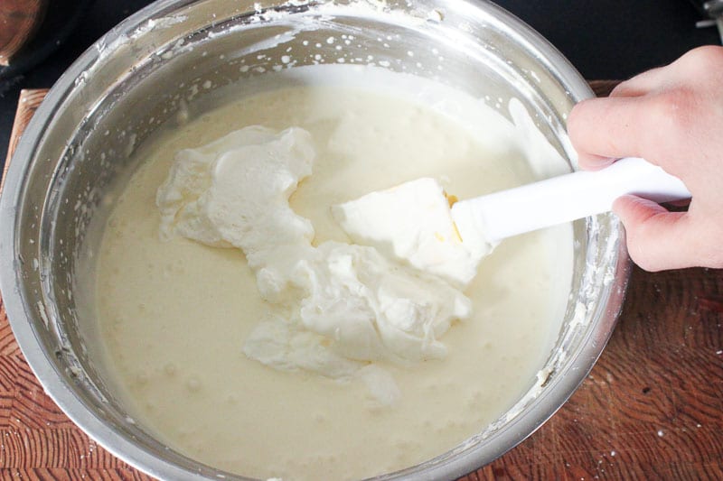 Folding Whipping Cream into Cream Cheese Mixture in Metal Mixing Bowl.