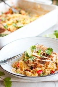 One Pan Thai Chicken and Rice Bake topped with Cilantro in White Plate.