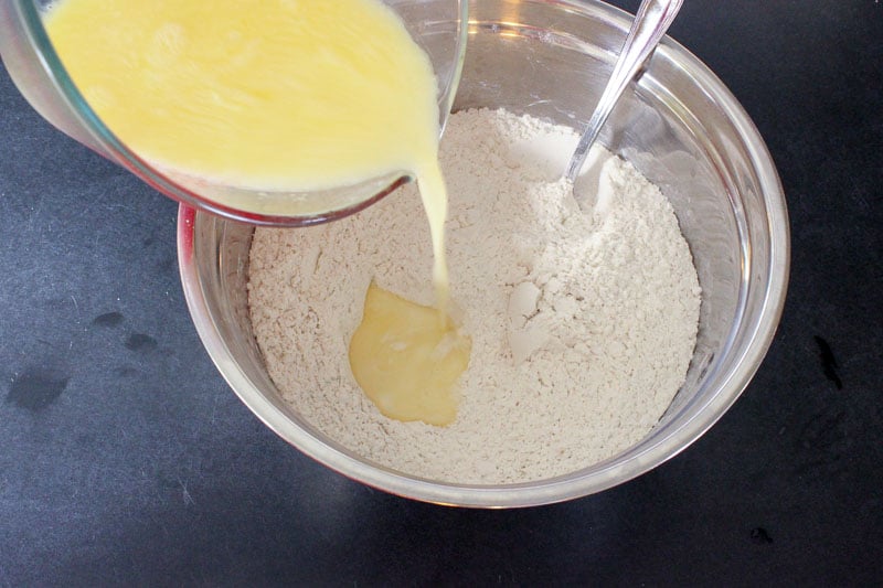 Adding Wet Ingredients to Dry Ingredients in Metal Mixing Bowl.