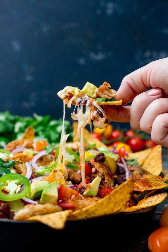 Nacho Chips topped with Tomatoes, Jalapeños, and Cheddar Cheese.