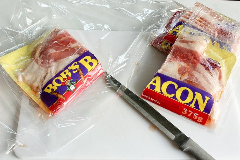 Bacon Package Cut in Half on White Board.