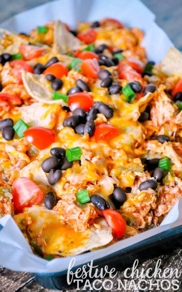 Chicken Taco Nachos Topped with Black Beans, Green Onions and Tomatoes.