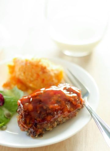 Mini meatloaf, salad and sweet potato on white plate.