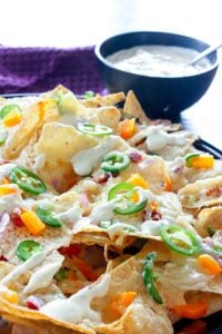 Jalapeno Popper Nachos with Garlic Cream Sauce are an easy, fun recipe to make for your next super bowl party or potluck