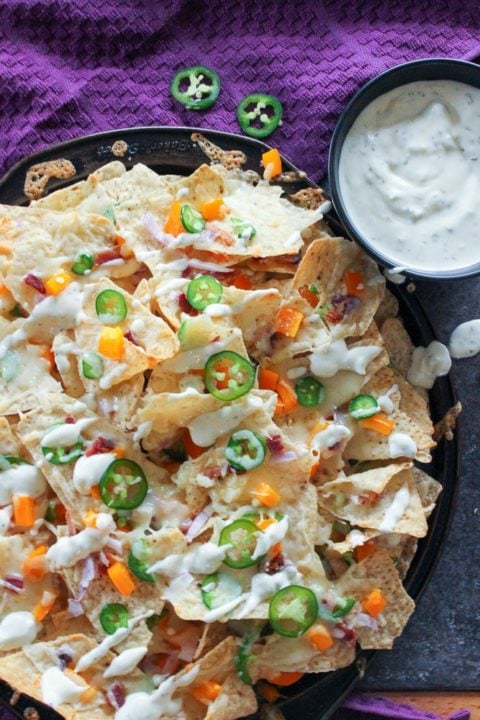 Nachos topped with jalapeños, peppers and cheese.