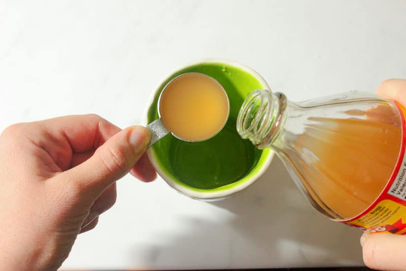 Pouring Apple Cider Vinegar into Measuring Spoon.