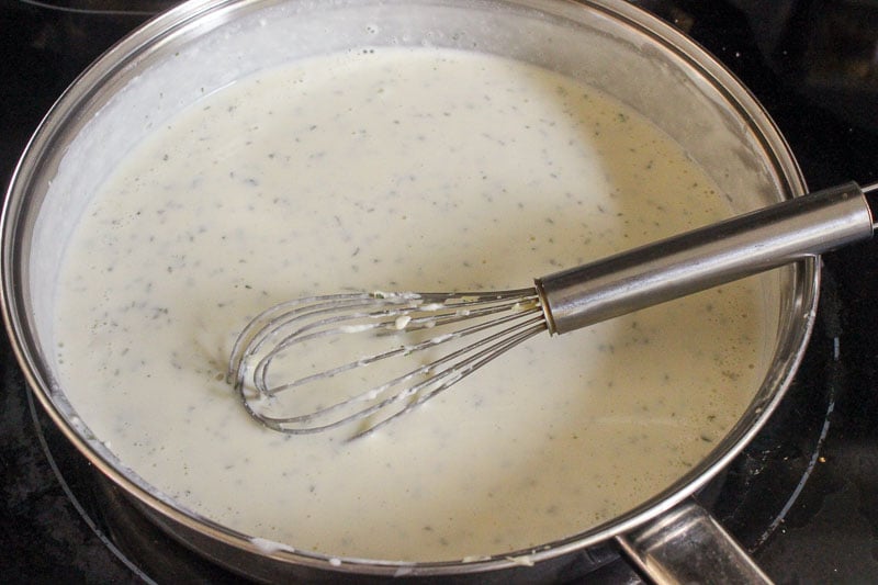 Mixing Garlic Cream Sauce in Frying Pan with Whisk.