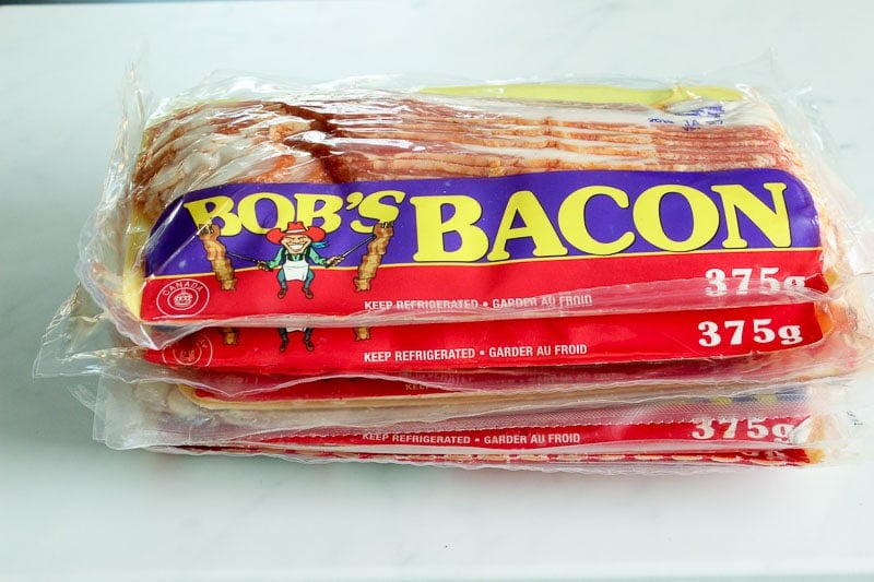 Stack of Packaged Bacon on a White Board.