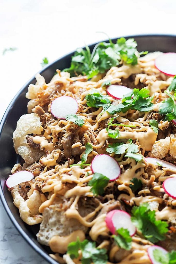 Pork Rinds topped with Cilantro, Sliced Radishes and Brown Sauce.