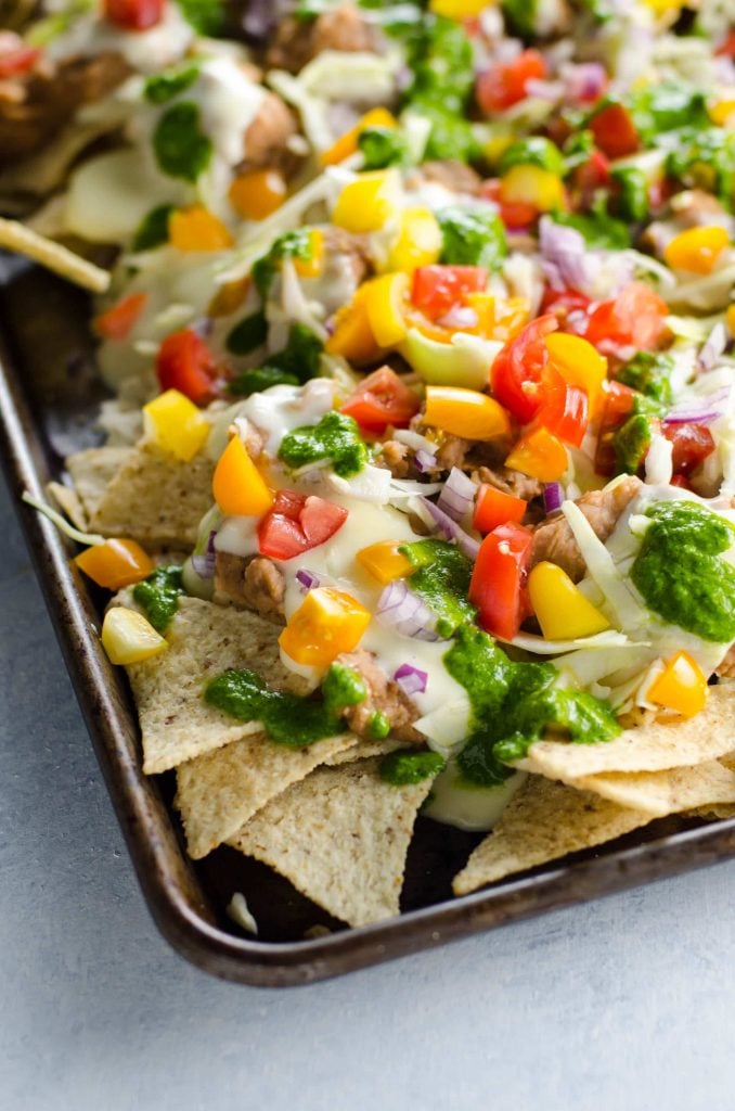 Nacho Chips topped with Yellow and Orange Peppers, Red Onions and Tomatoes.