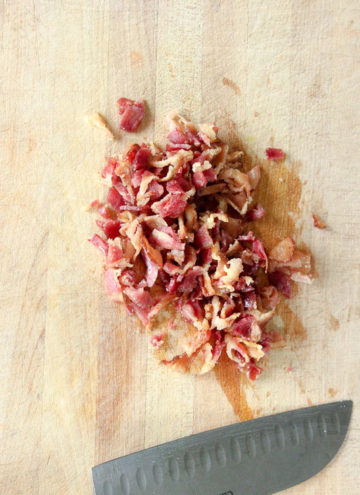 Chopped bacon on wooden cutting board.