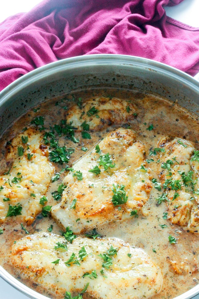 Chicken Breasts in Creamy Sauce in Frying Pan Topped with Parsley.