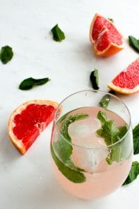 Grapefruit Mint Infused Water, Ice Cubes and Mint Leaves in Stemless Wine Glass.