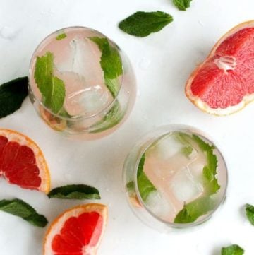 Mint leaves floating in glasses of grapefruit water.