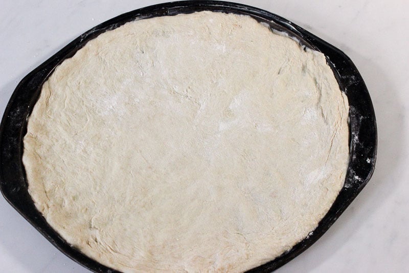 Pizza Dough Spread on Round Pizza Pan.