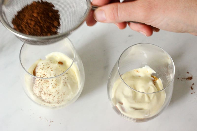 Sprinkling Cocoa Powder onto Custard Layer of Tiramisu.