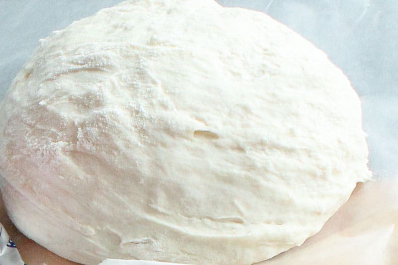Ball of Pizza Dough on Parchment Paper.