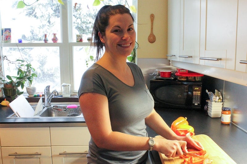 Women Chopping Red and Yellow Peppers on Wooden Cutting Board.