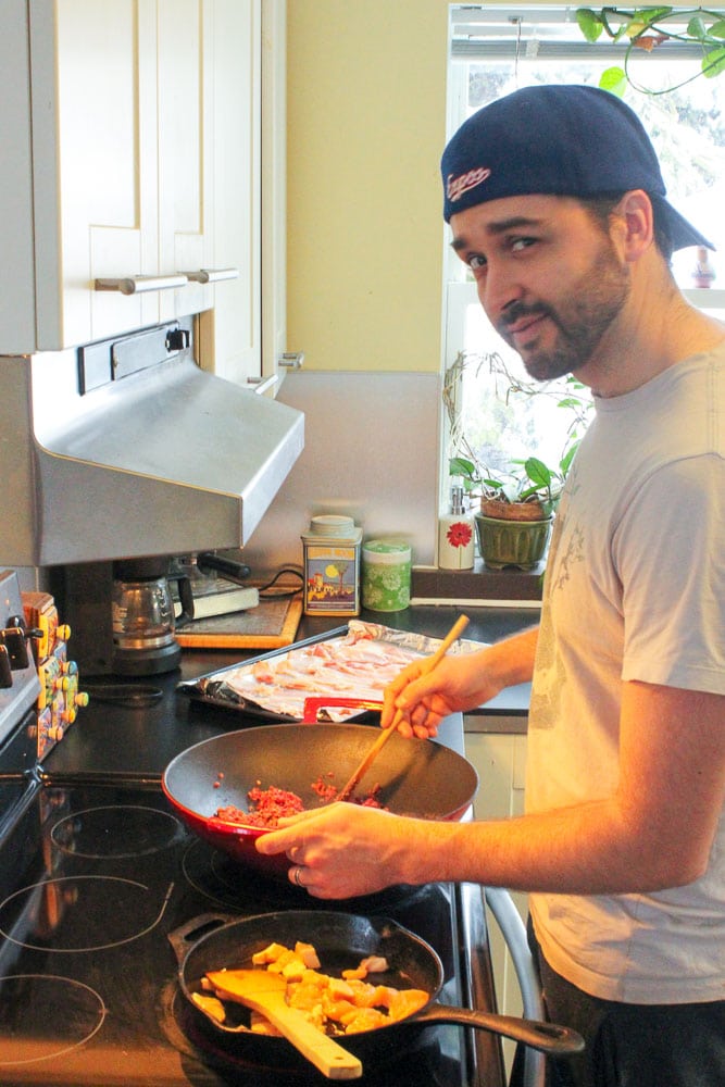 Man with Backwards Hat Cooking Ground Beef in Wok.