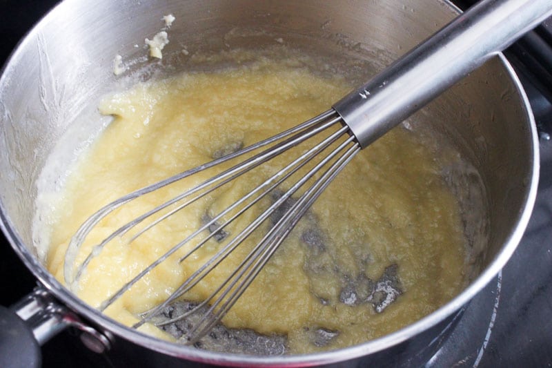 Mixing flour and butter mixture with Whisk in pot.