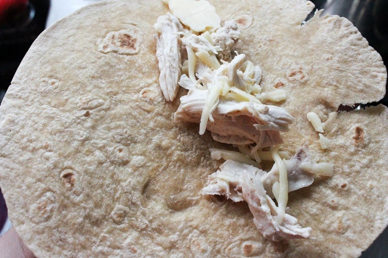 Putting Shredded Chicken and Shredded Mozzarella Cheese in Tortilla.