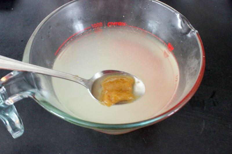 Adding Chicken Bouillon to Hot Water in Glass Measuring Cup.