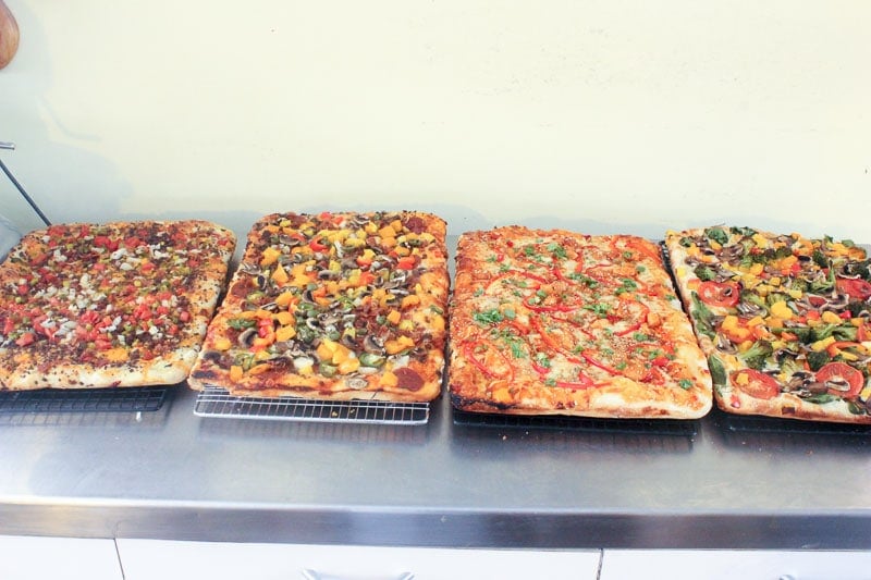 Four Cooked Different Pizzas on Wire Cooling Racks.