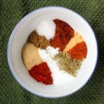 Small white bowl full of colourful herbs and spices.