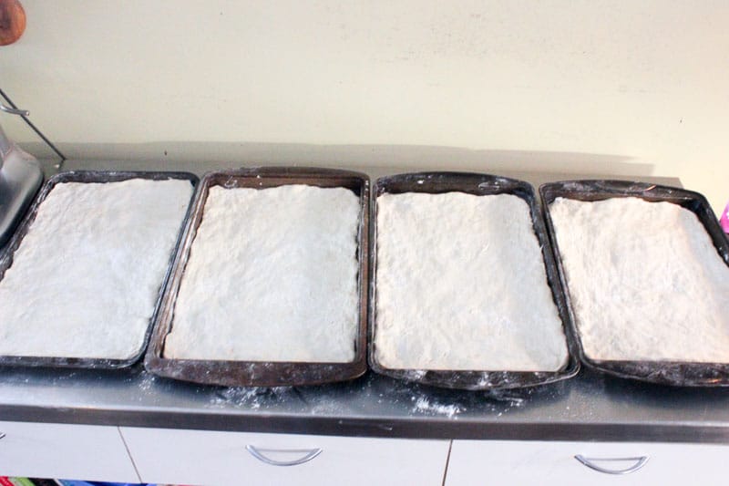 Pizza Dough Spread in Four Rectangular Sheet Pans.