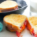 Sliced grilled cheese with tomato.