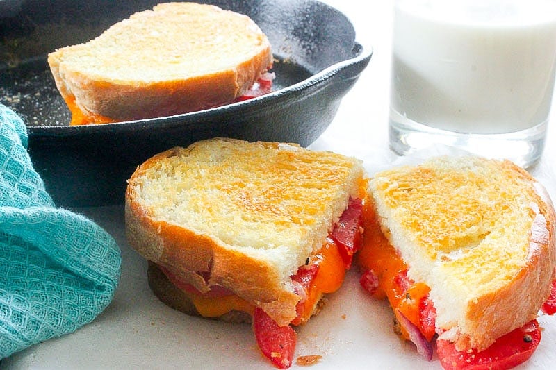 Sliced grilled cheese with tomato.