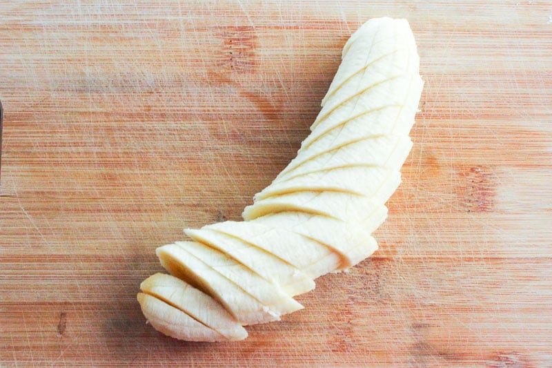 Sliced banana on a wooden cutting board.
