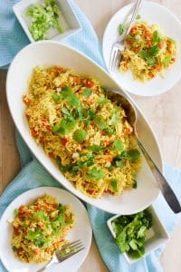 White Oval Serving dish of curry chicken and rice topped with Cilantro.