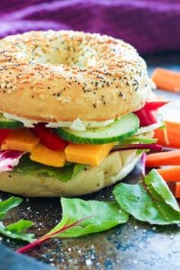 Everything bagel sandwich with vegetables and cheese.