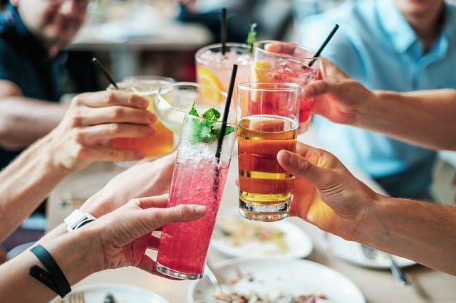 People hitting their drink filled glasses together.