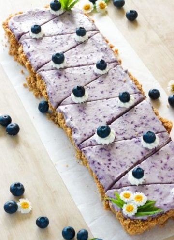 Sliced no bake blueberry cheesecake on white plate.