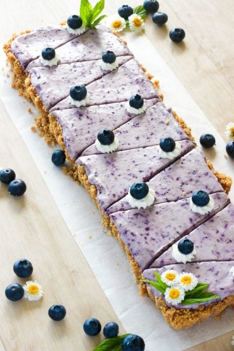 Sliced no bake blueberry cheesecake on white plate.