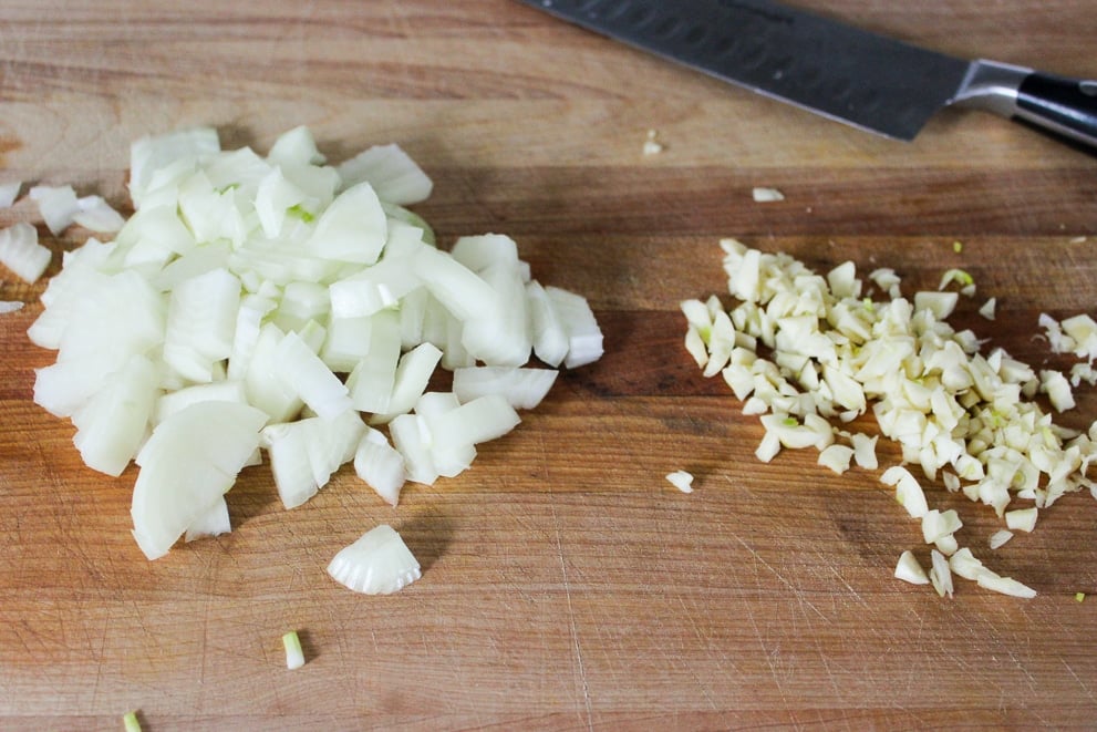 Diced onion and minced garlic on a cutting board