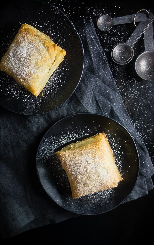 Nutella banana puff pastries on black plates with black napkins