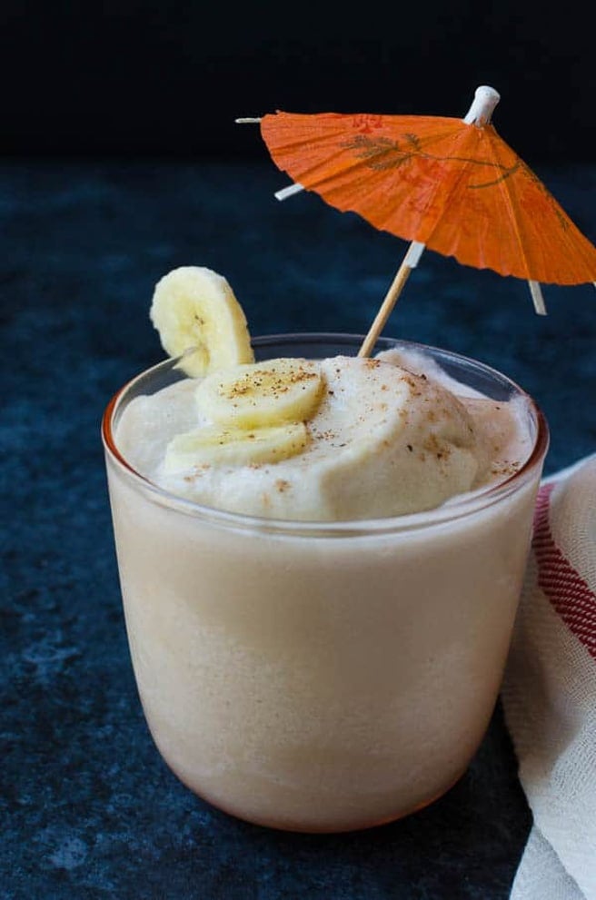 Banana cocktail with umbrella in glass