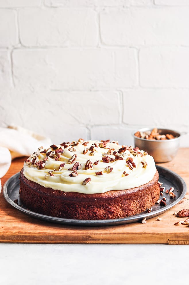 Banana cake with nuts on top of cream cheese frosting