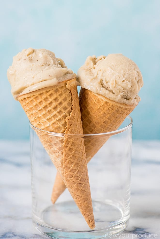 Two ice cream cones filled with banana ice cream, standing in a glass