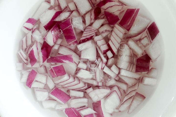 Minced red onion in a bowl of water