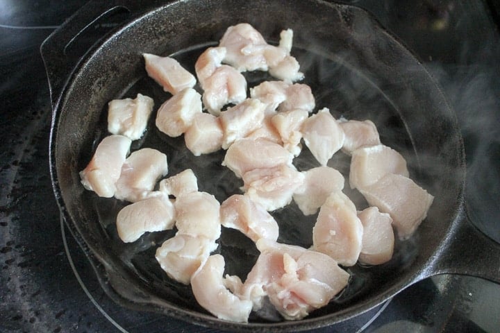 Chunks of chicken cooking in a frying pan