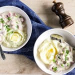 Two bowls of creamed ham in a white sauce, served with mashed potatoes