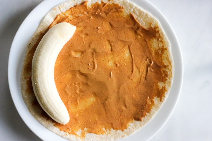 Tortilla spread with peanut butter with a banana in it