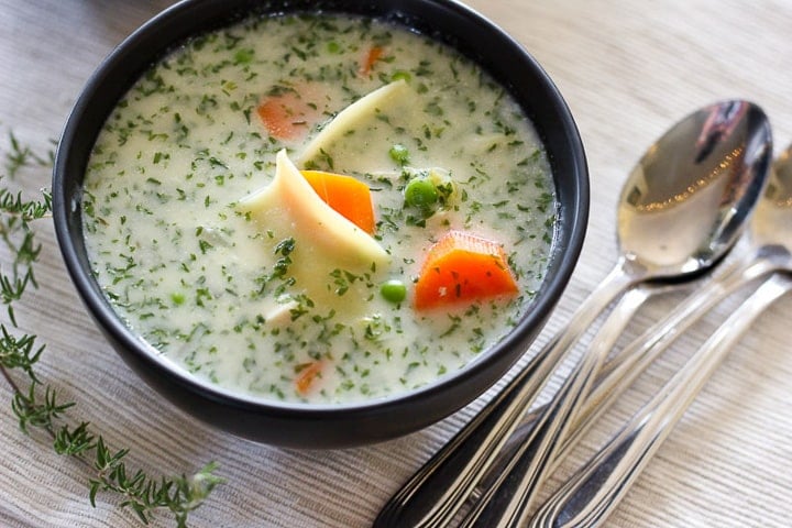 Creamy chicken soup with egg noodles in black bowl