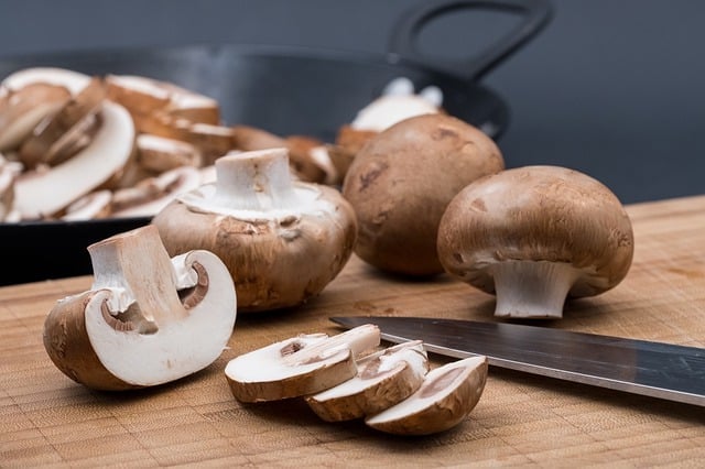 sliced and whole mushrooms on a cutting board