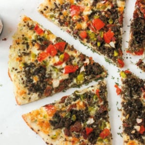 Pizza slices topped with beef and vegetables on white background.