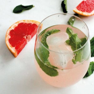 Grapefruit juice and mint leaves in glass.
